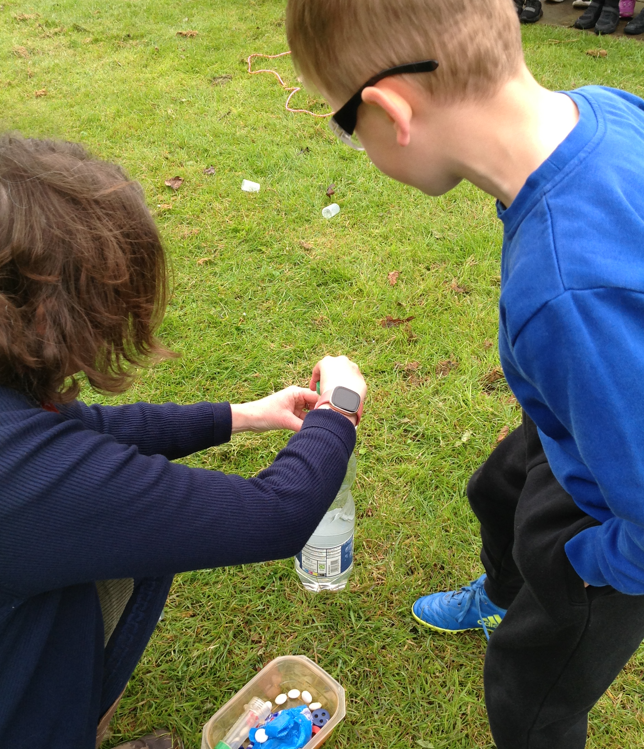 A child and child looking at a watch Description automatically generated